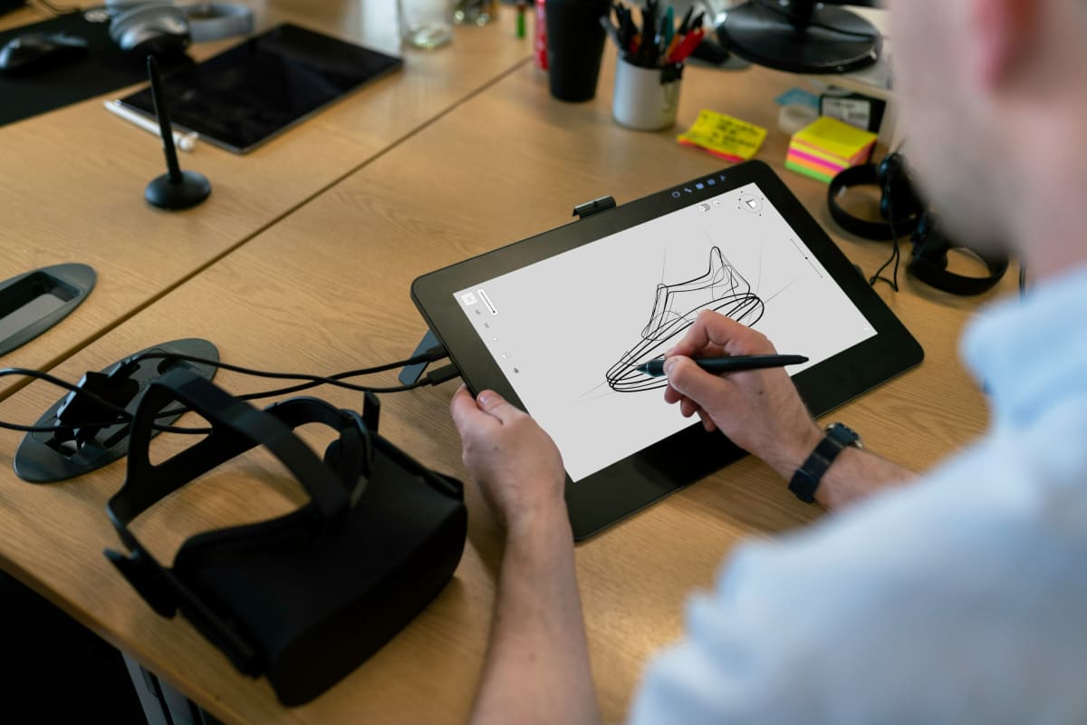 Artist working with digital tablet creating illustrations alongside AI collaboration tools