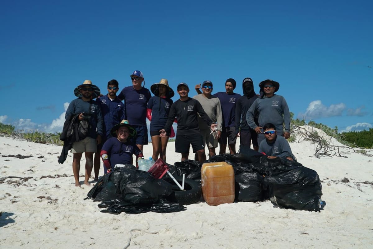 Sea Shepherd crew members collecting plastic debris on beach at Isla Desterrada in Mexico's Scorpion Reef