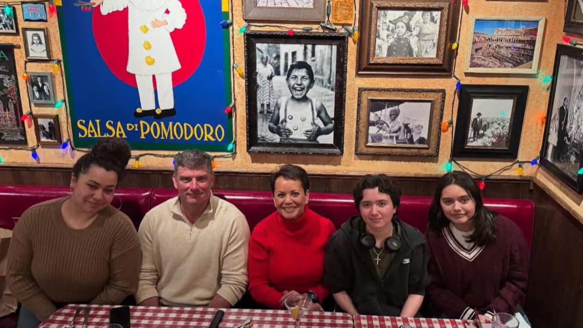 Jovita McConnell in red shirt smiling with her family during her recovery journey