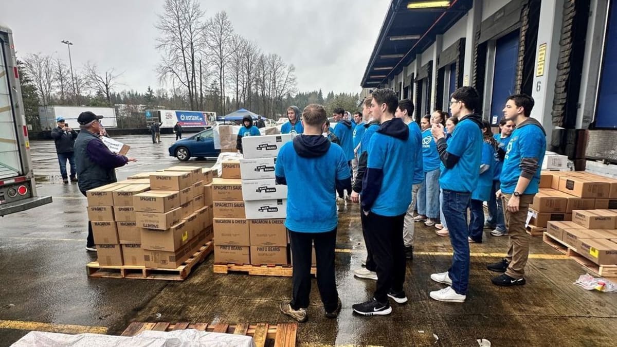 Volunteers unloading boxes of food from semi-truck at Bellevue warehouse distribution center
