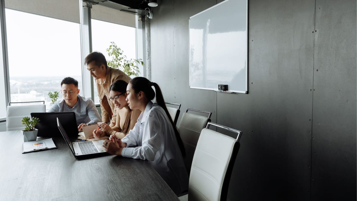 ** Diverse team collaborating together in modern office workspace with technology