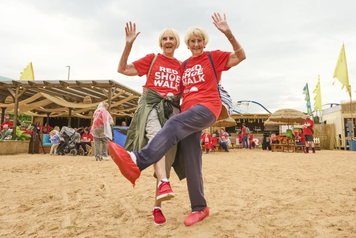 Group of people walking together wearing red shoes at community charity fundraiser event