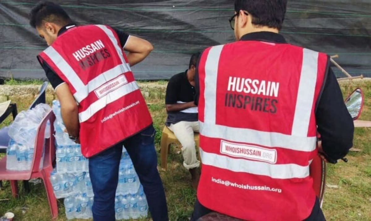 Volunteers in branded jackets distributing food and supplies to people in need on city street