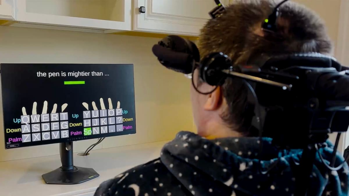 Person with tetraplegia using brain implant system to type on digital keyboard display
