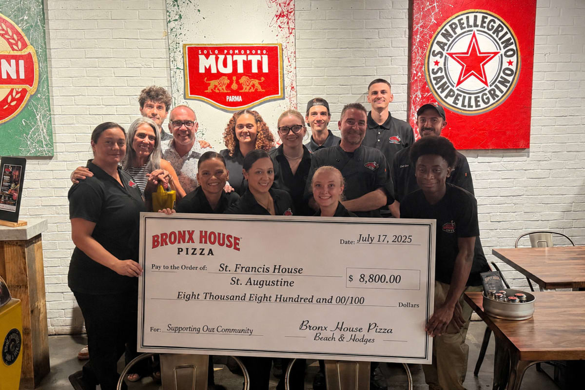 Crowded pizza restaurant filled with diners attending charity fundraiser for homeless programs