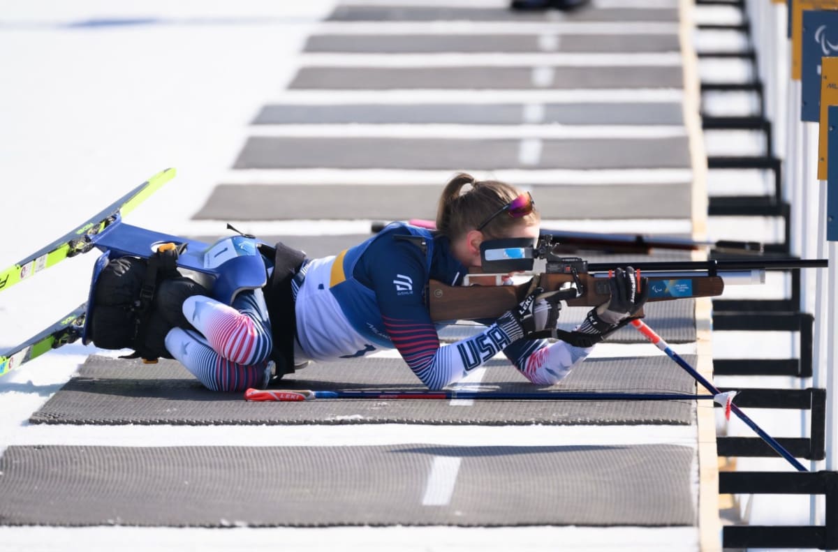 U.S. Para Nordic ski team members celebrating on snow with American flags
