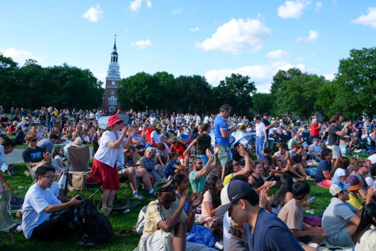 Large crowd gathered on college green watching World Cup final on outdoor screen