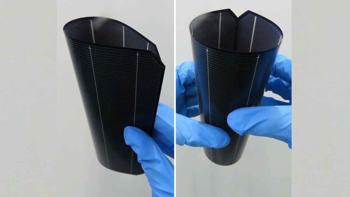 Ultra-thin flexible solar cell being bent by researcher in laboratory setting