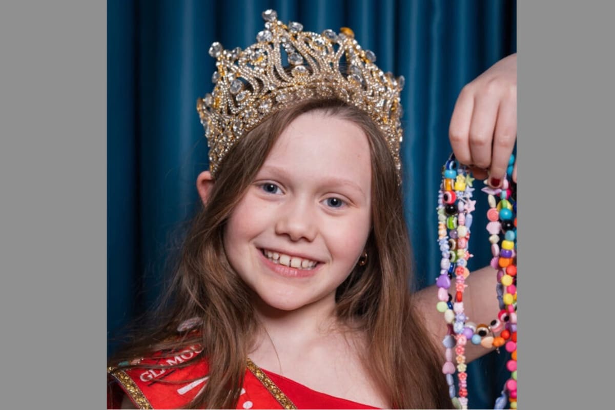 Young girl with autism proudly displaying colorful handmade charity bracelets she created for hospice fundraising