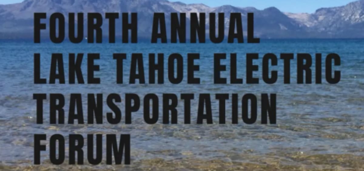 Electric boat gliding across clear blue waters of Lake Tahoe with mountains behind