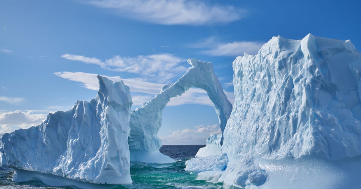 Shallow brine pond surrounded by ice and rock in Antarctica's stark dry valley landscape