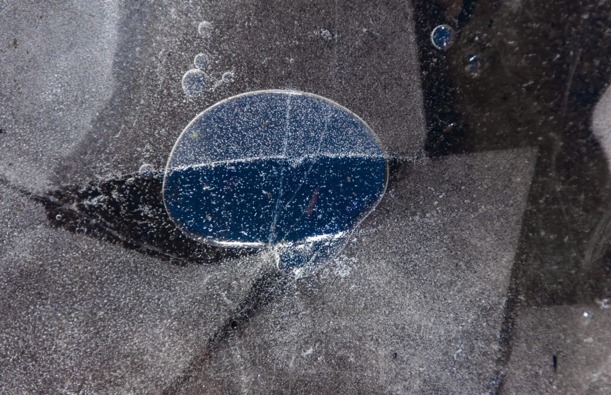 Artist rendering of icy moon with cracked surface revealing ocean beneath frozen shell