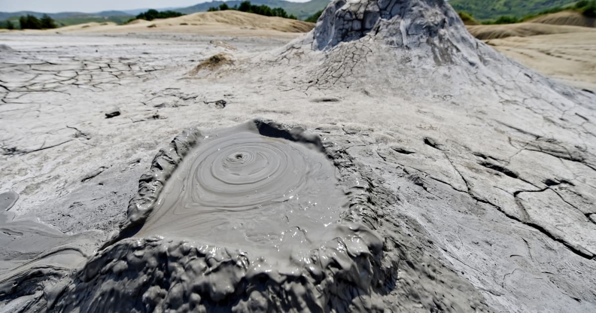 ** Deep ocean mud volcano venting alkaline fluid on dark seafloor near Mariana Trench
