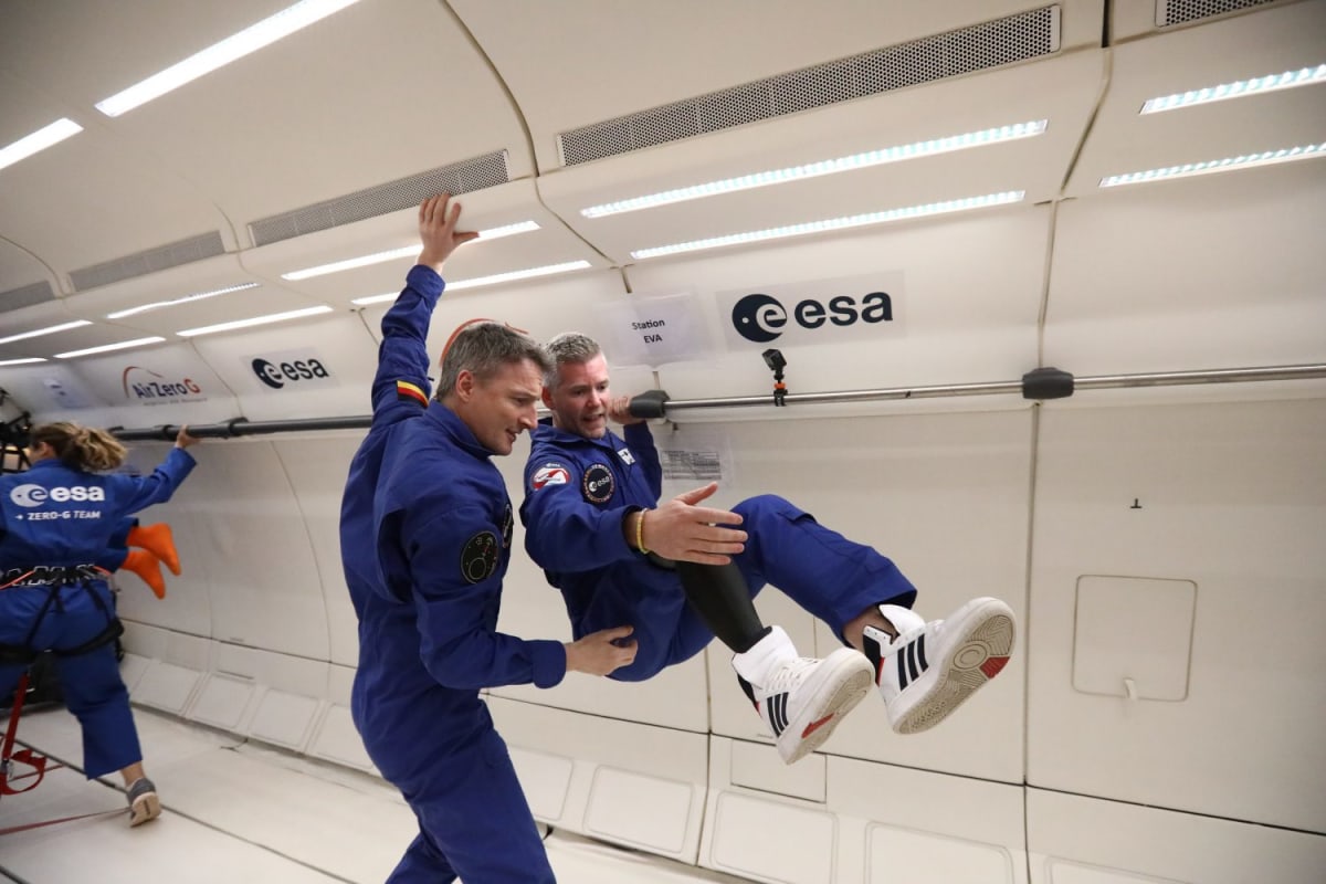John McFall in astronaut training gear smiling at camera with prosthetic leg visible