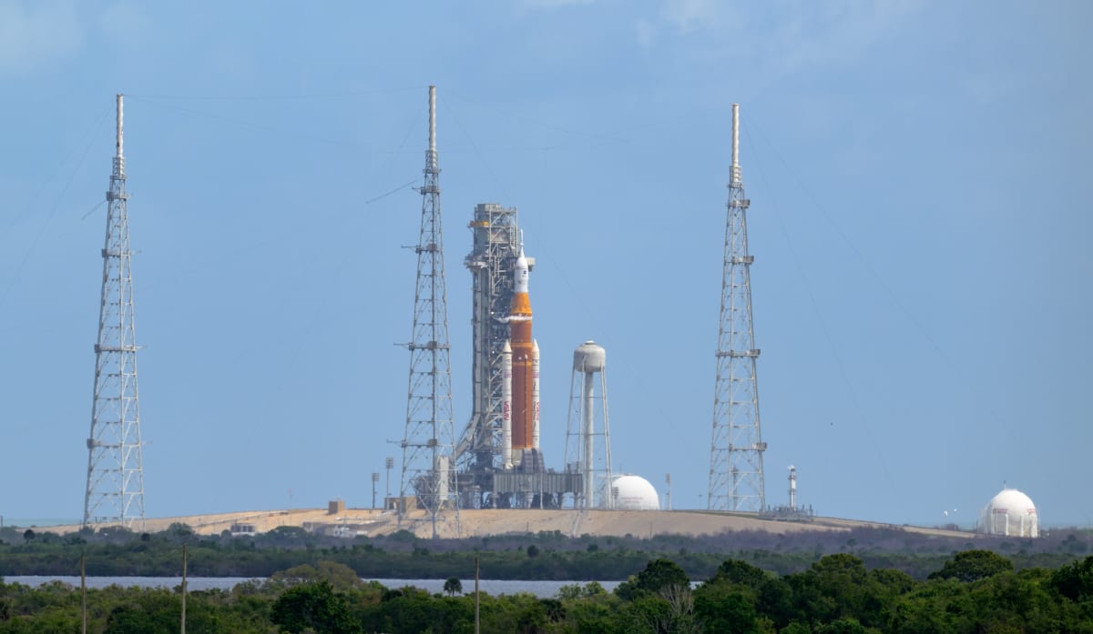 Orion spacecraft in orbit above Earth with moon visible in background during Artemis mission