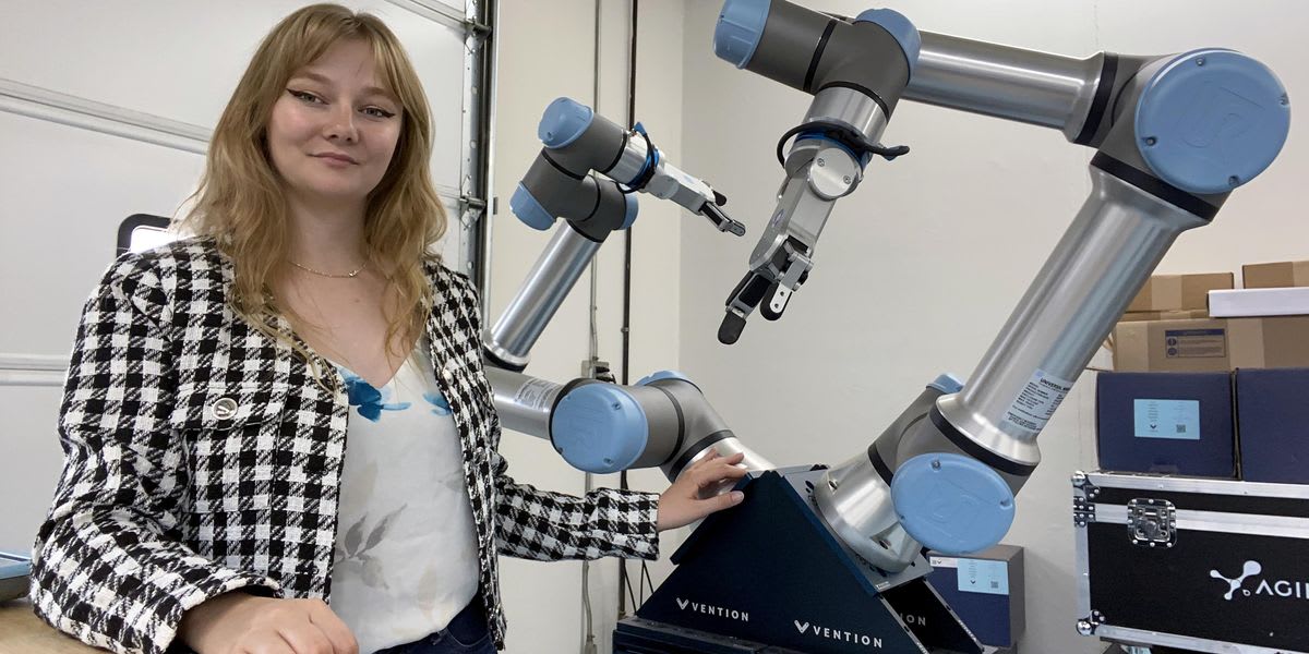 Graduate student Sarah Downs working with robotic equipment for NASA satellite assembly research