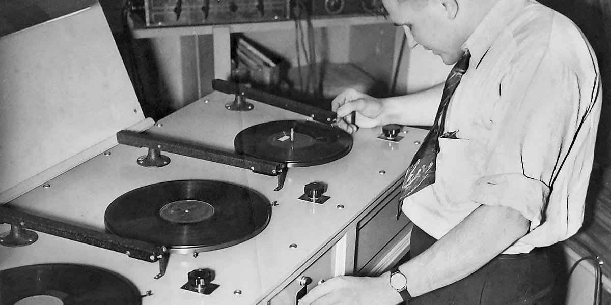 Elderly Gerard Gus Gaynor operating vintage radio equipment at high school radio club meeting