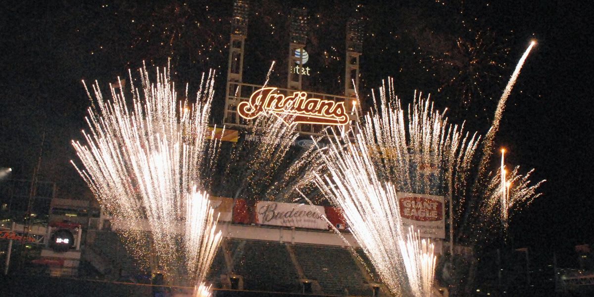 Colorful fireworks exploding over nighttime city skyline during Fourth of July celebration
