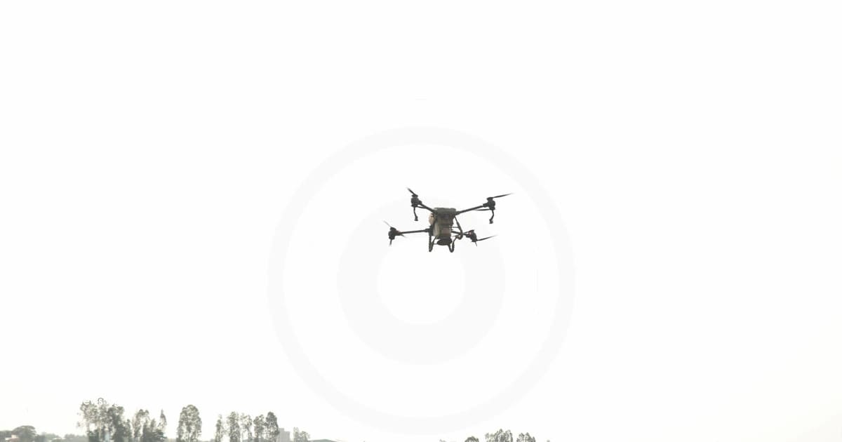 Drone flying over Vietnam's mountainous terrain delivering supplies to remote village below