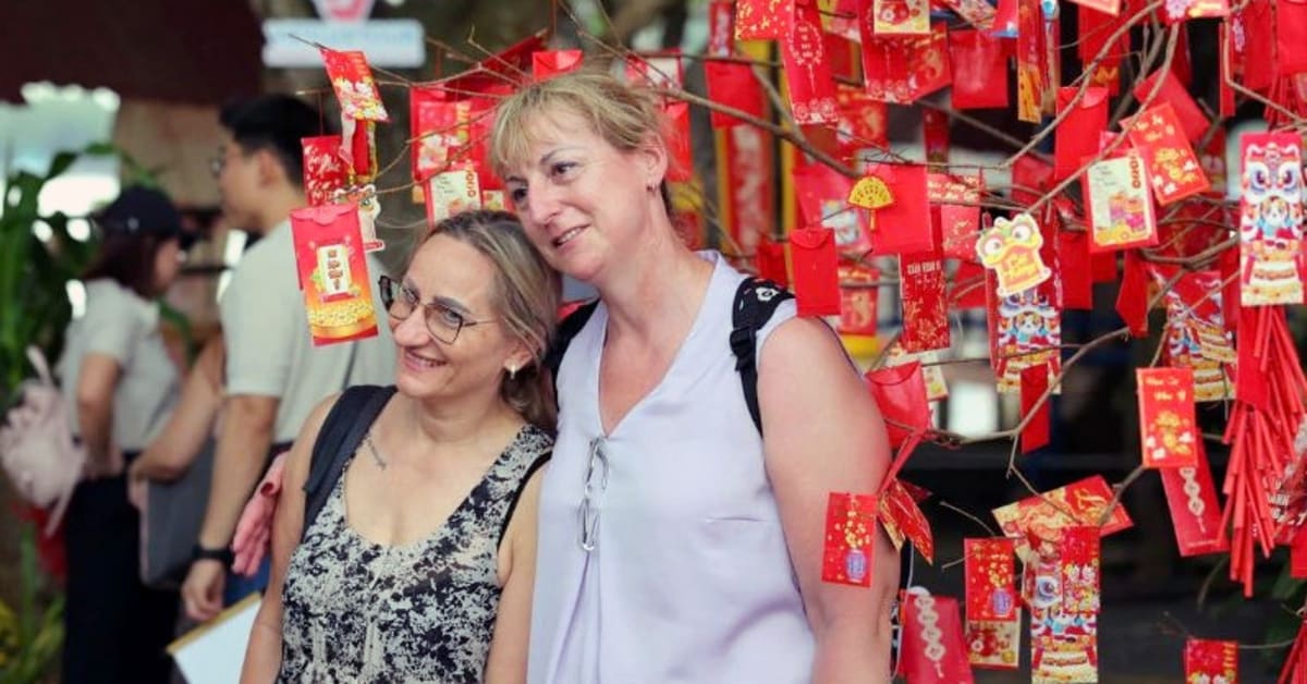 Tourists exploring vibrant Vietnamese coastal city with traditional boats and modern skyline