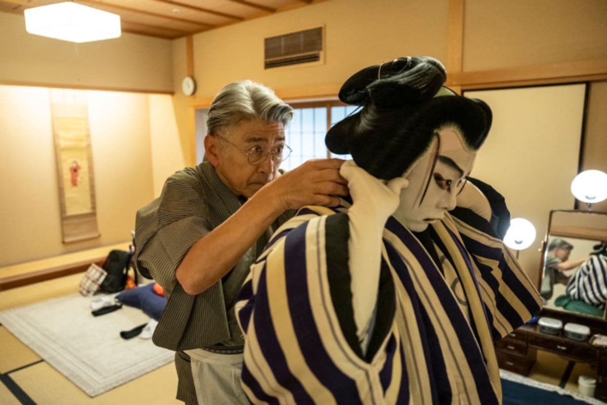 Kabuki wig master Tadashi Kamoji carefully styling elaborate traditional wig at Tokyo theater