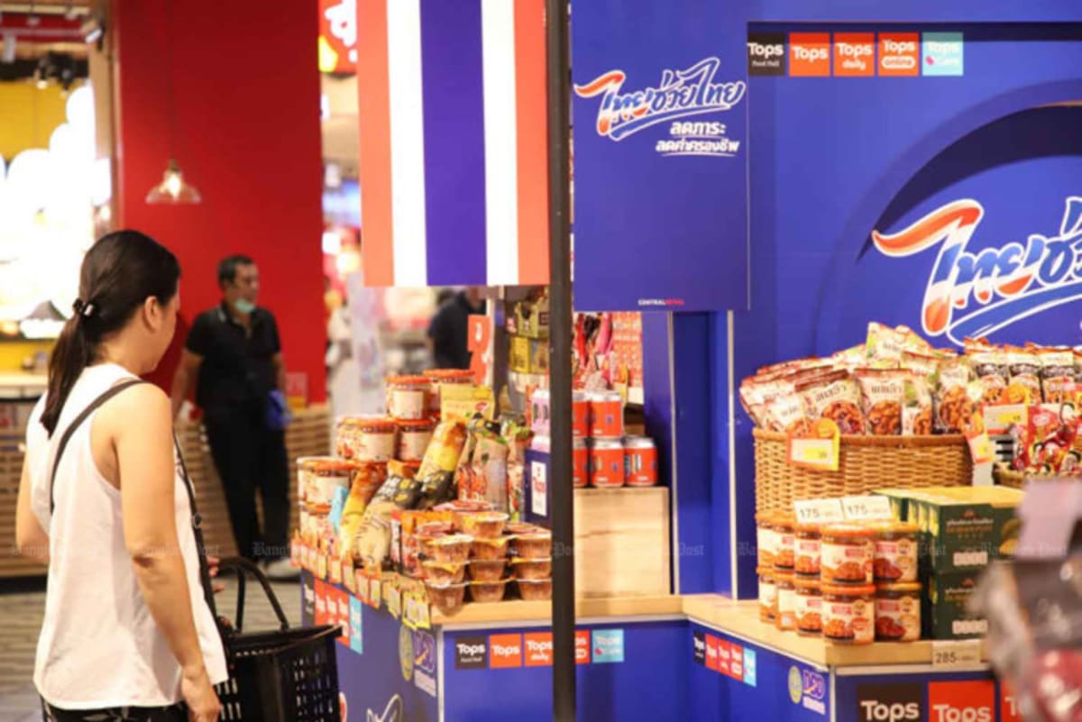 Thai families shopping at local market with discounted consumer products displayed on shelves