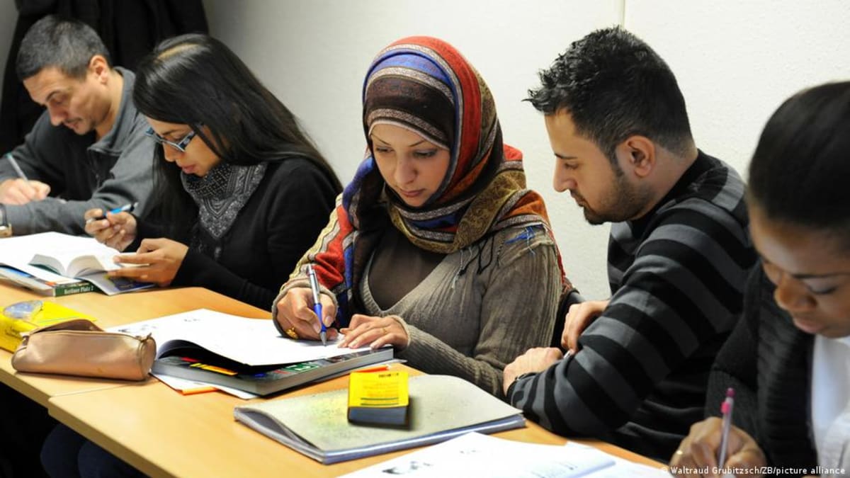 ** People participating in a German language integration course, learning together in a classroom setting