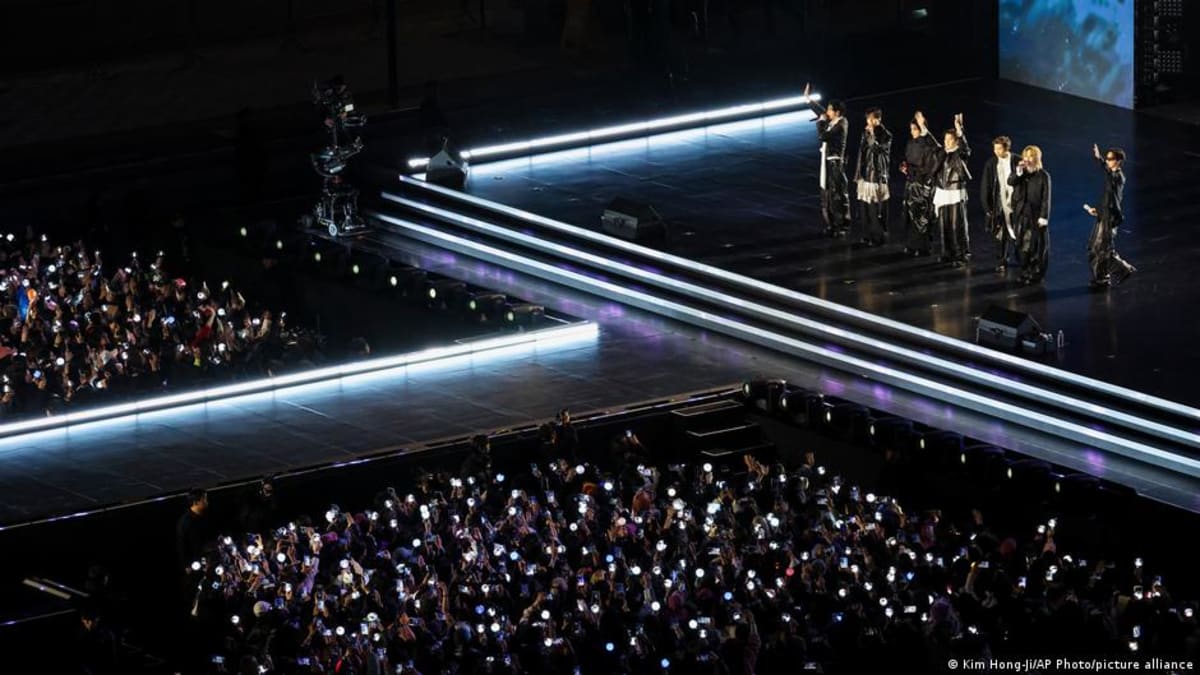 BTS performs on illuminated stage at Gwanghwamun Square in Seoul with thousands of fans holding light sticks