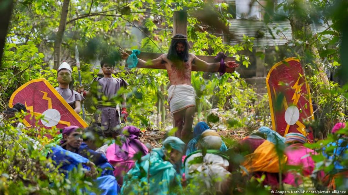 ** Christian devotees participating in solemn Good Friday procession in India holding religious symbols
