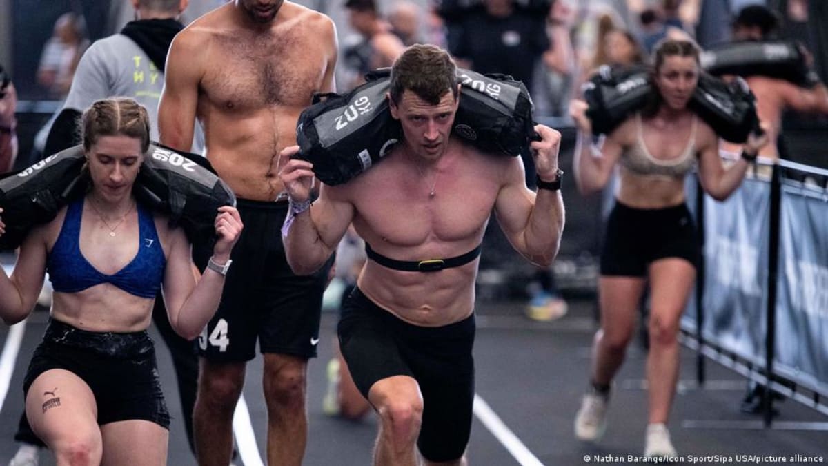 Athletes competing in Hyrox fitness competition combining running with functional strength training stations