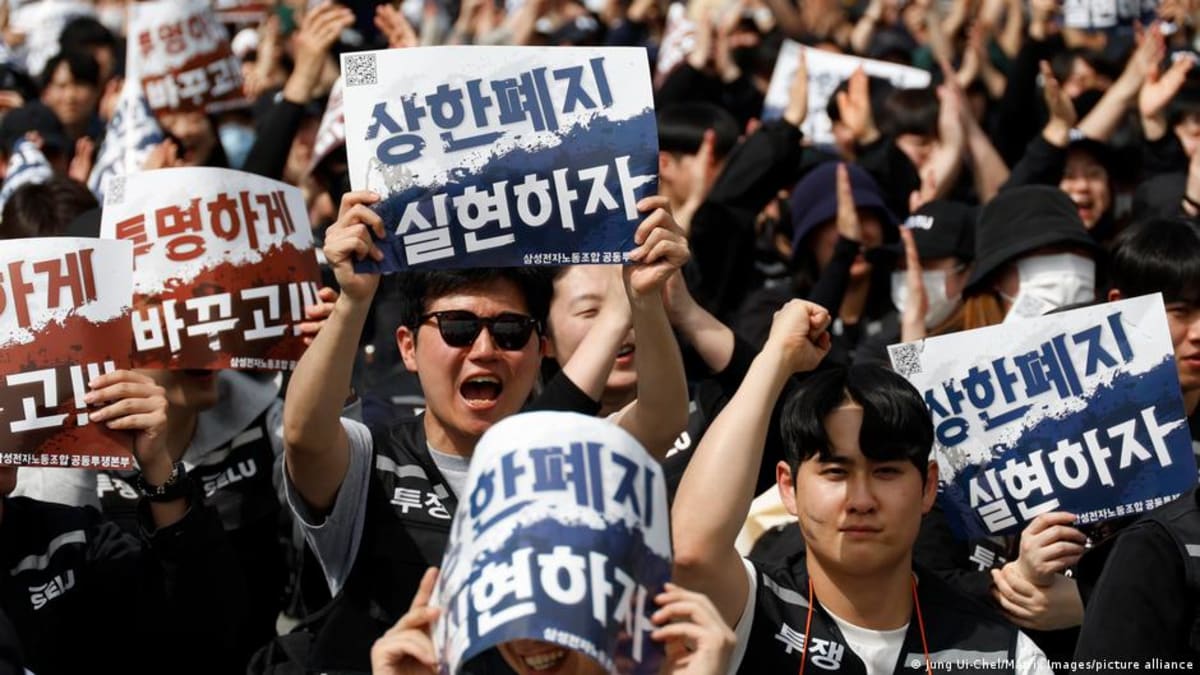 Samsung Electronics workers holding protest signs demanding transparent compensation at Pyeongtaek manufacturing facility
