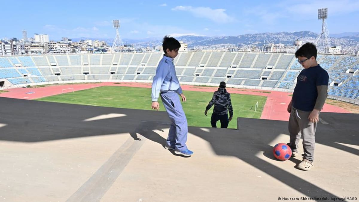 Children practice martial arts with coach Hassan Seif al-Din inside Beirut stadium refugee shelter