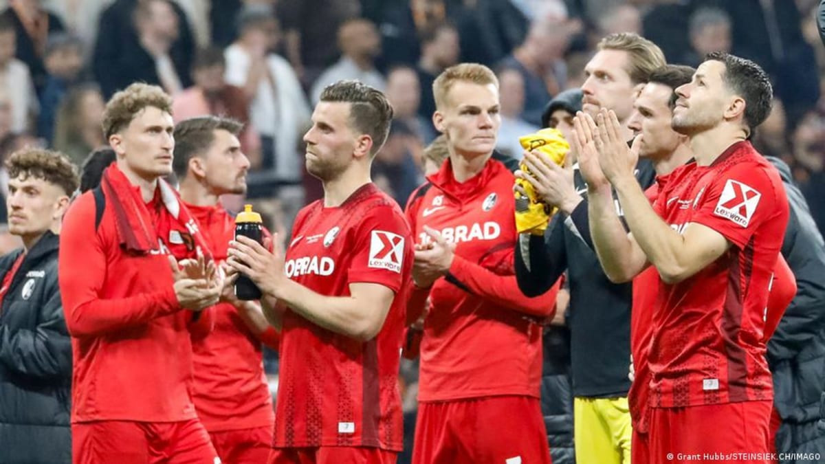 ** Crowded stadium stands filled with enthusiastic soccer fans cheering at women's Bundesliga match in Germany