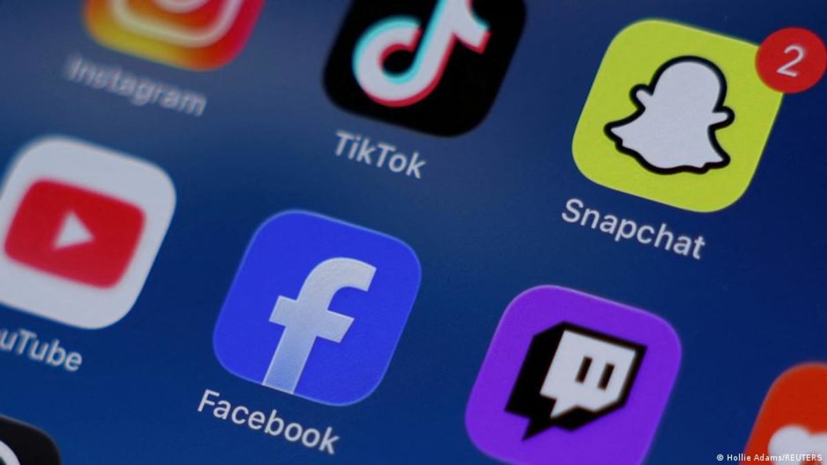 Teenager using smartphone displaying social media apps in dimly lit room