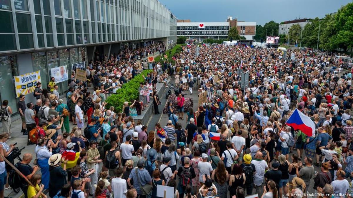 Protesters march through Prague streets carrying banners defending public media independence