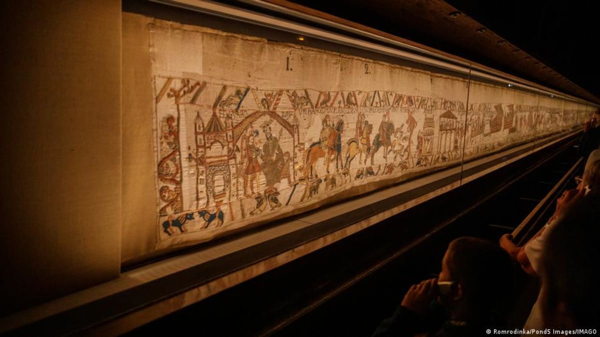 Workers and diplomats applaud as climate-controlled case containing Bayeux Tapestry arrives at British Museum