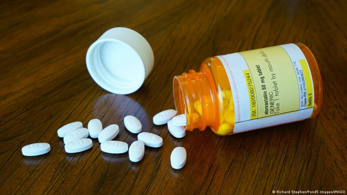 Medical illustration showing statin medication pills next to healthy brain and heart imagery