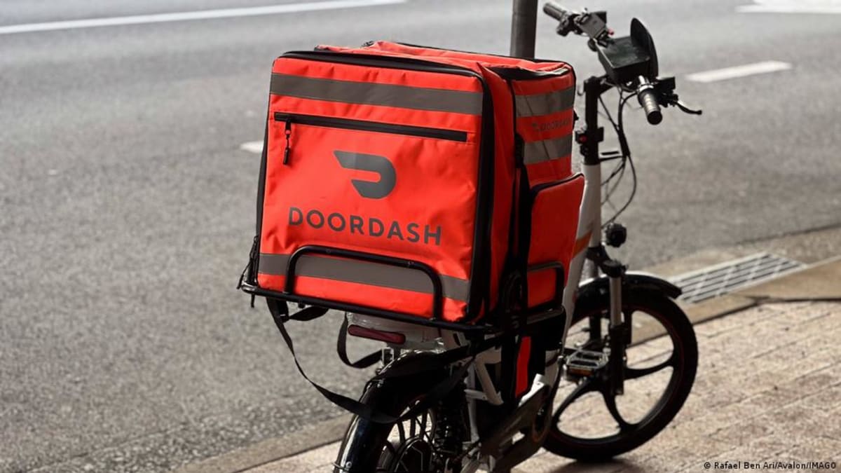 Food delivery rider on motorcycle navigating city streets in Australia during daytime