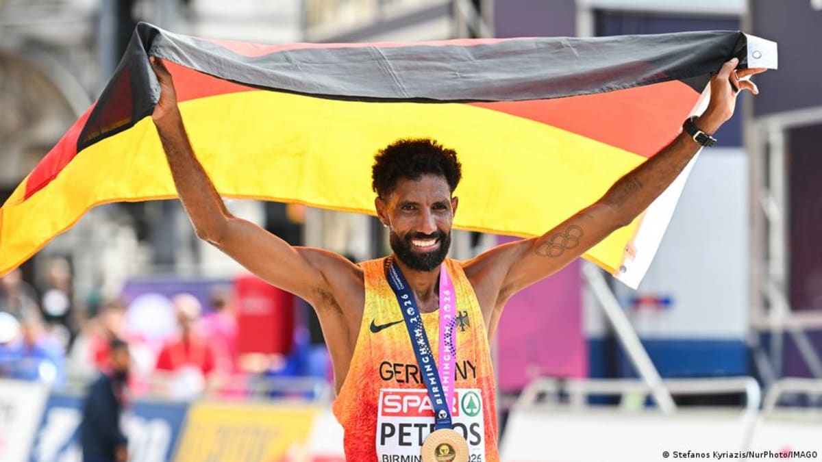 Amanal Petros celebrates with German flag draped over shoulders after winning European marathon gold