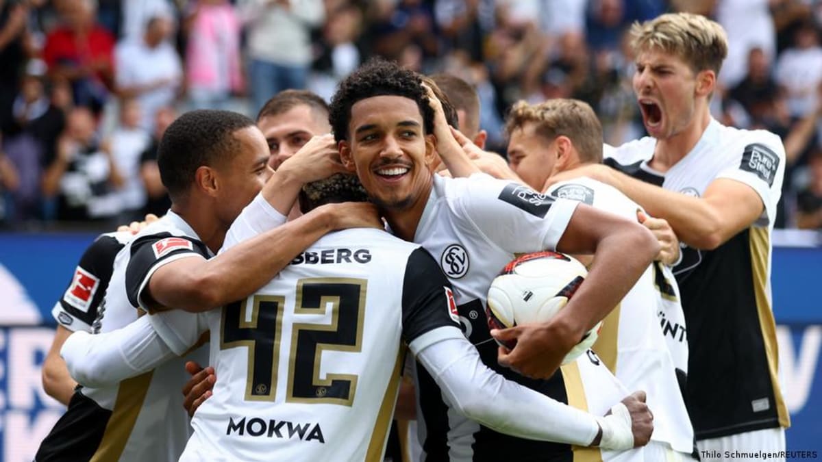 Elversberg soccer players celebrating on field after winning Bundesliga match against champions
