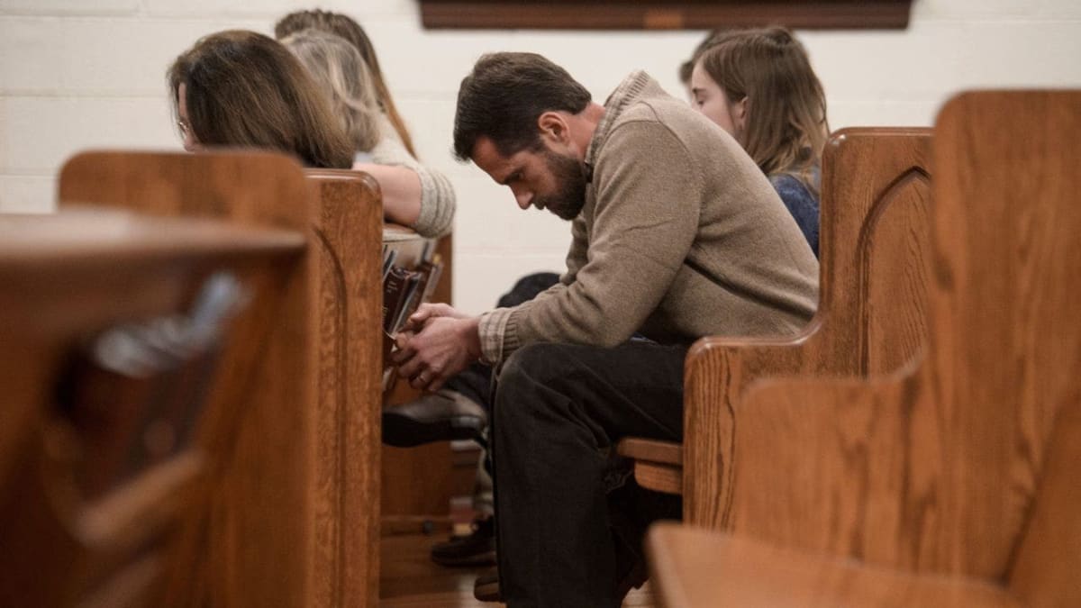 Young adults sitting together in church pews during Sunday worship service