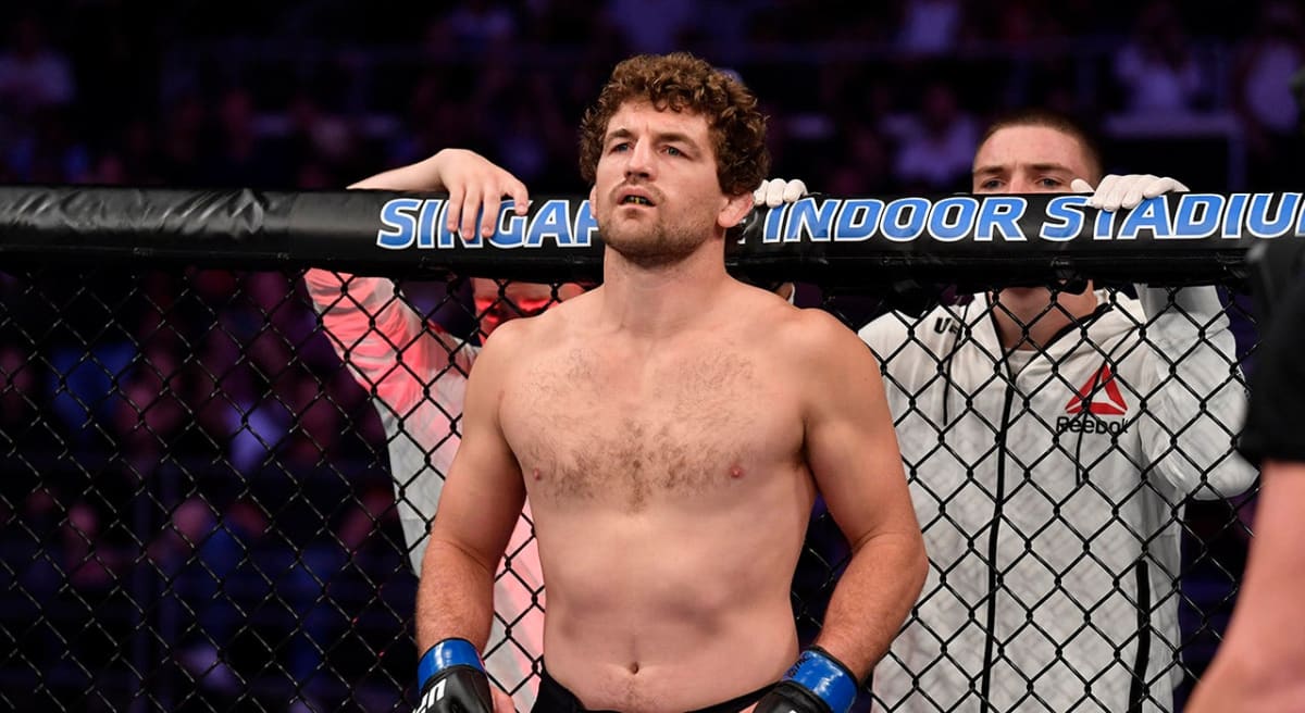 Ben Askren at a press conference in fighting gear, smiling confidently before his comeback match