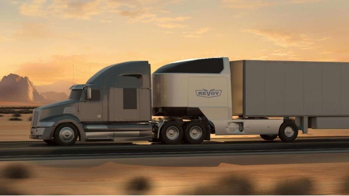 ** Military veteran in truck cab wearing cap, looking confidently at road ahead
