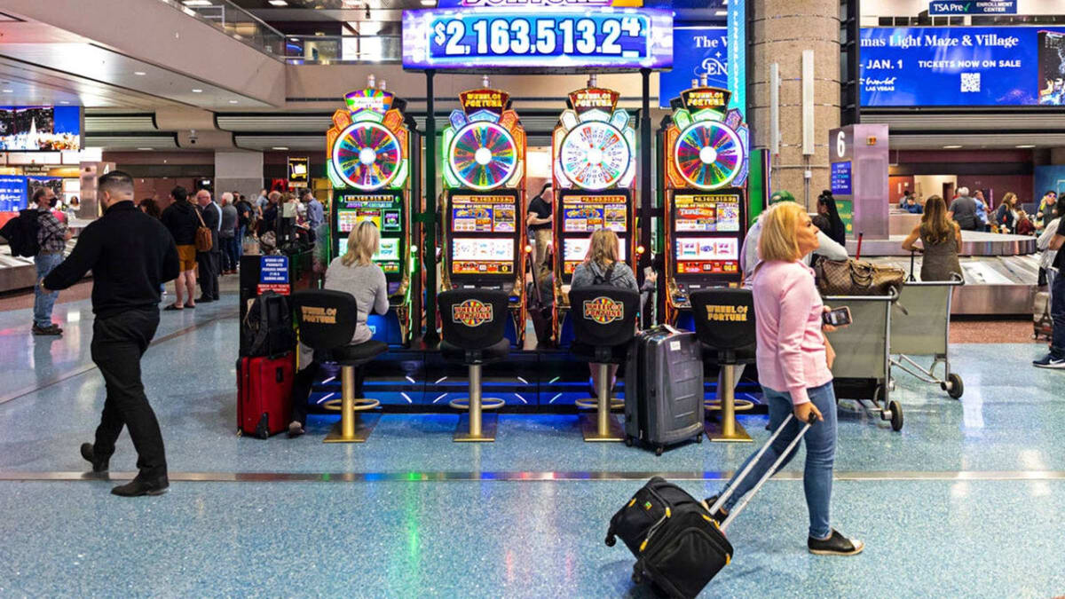 Wheel of Fortune slot machines inside Las Vegas airport terminal with bright colorful displays