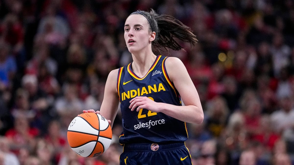 Caitlin Clark in Indiana Fever uniform dribbling basketball during professional game