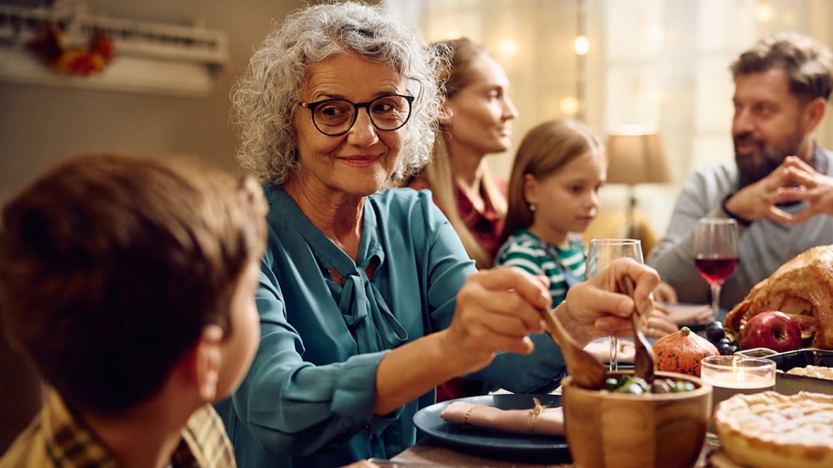 Grandmother and granddaughter cooking together in bright kitchen, sharing quality time over homemade meal