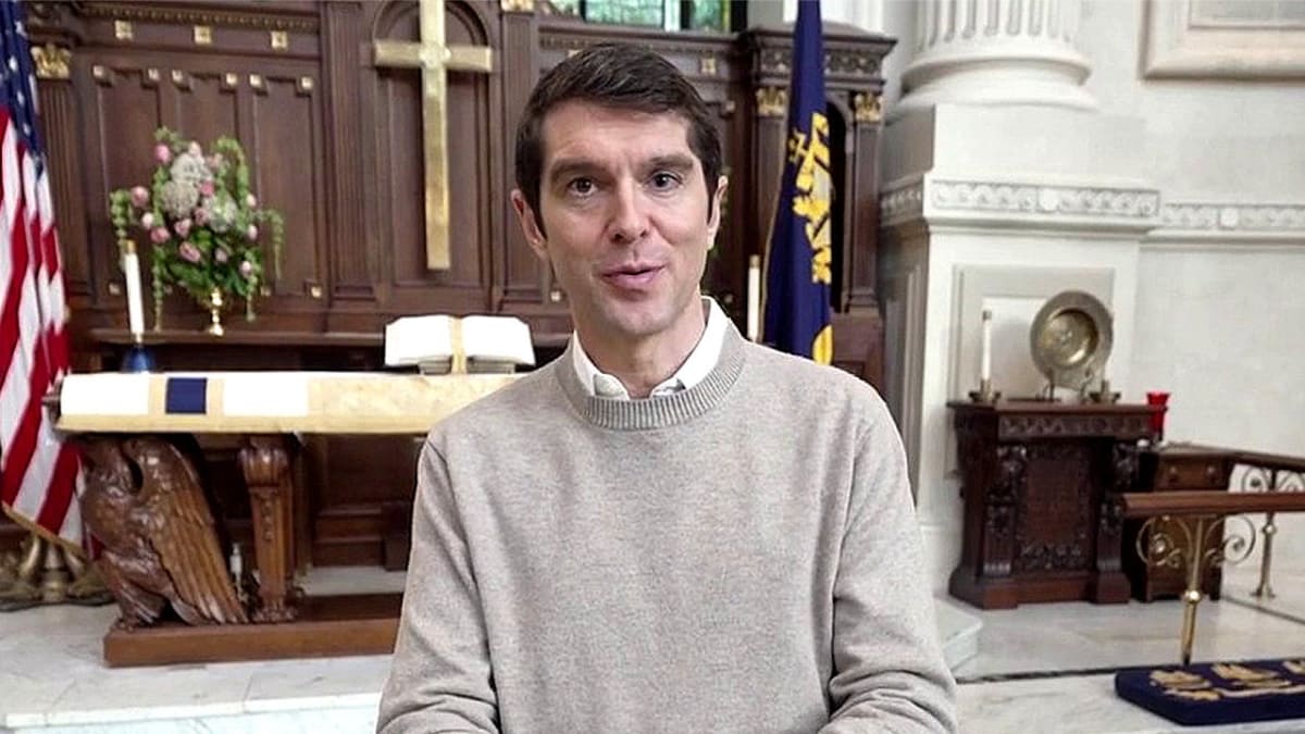 Benjamin Hall standing inside historic church sanctuary with stained glass windows and ornate architecture