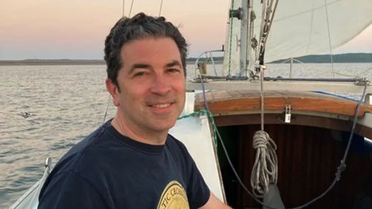 Dr. Brent Beasley smiling while walking outdoors with his young grandson Frank in Kansas park