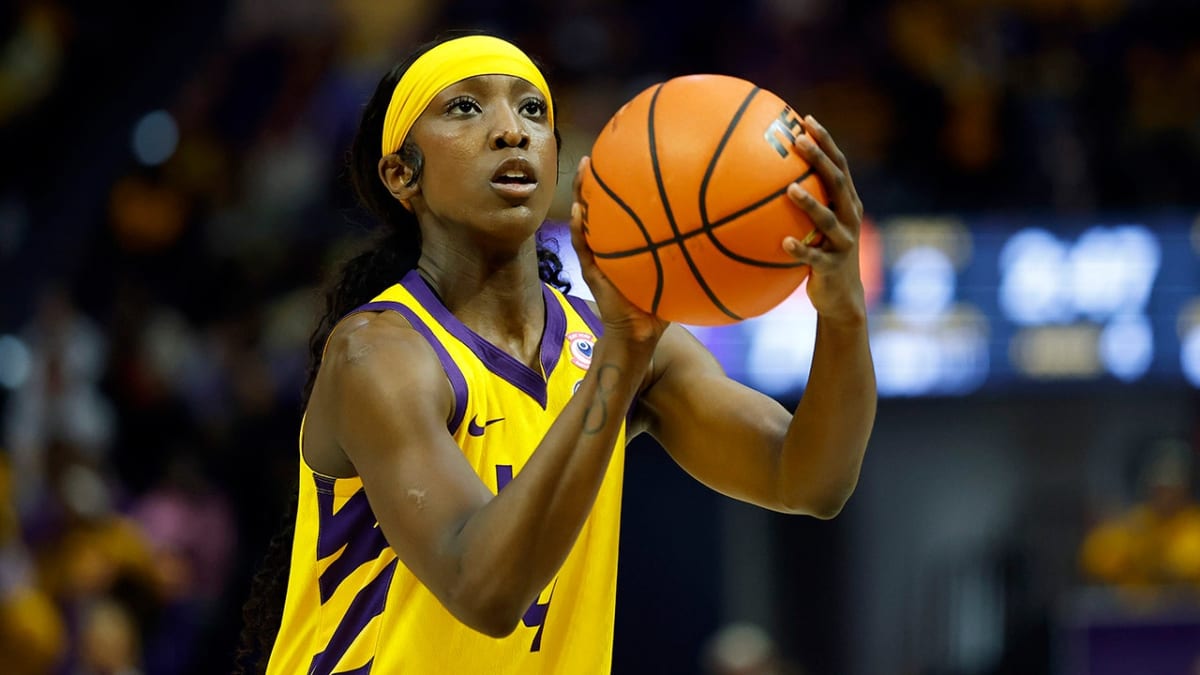 LSU basketball player Flau'jae Johnson dribbles down court in purple and gold Tigers uniform