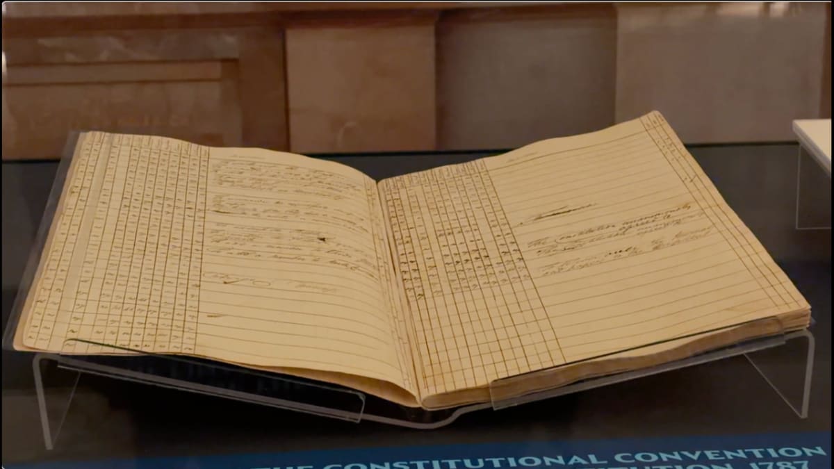 Historic founding document displayed in protective glass case at Freedom Plane museum exhibit